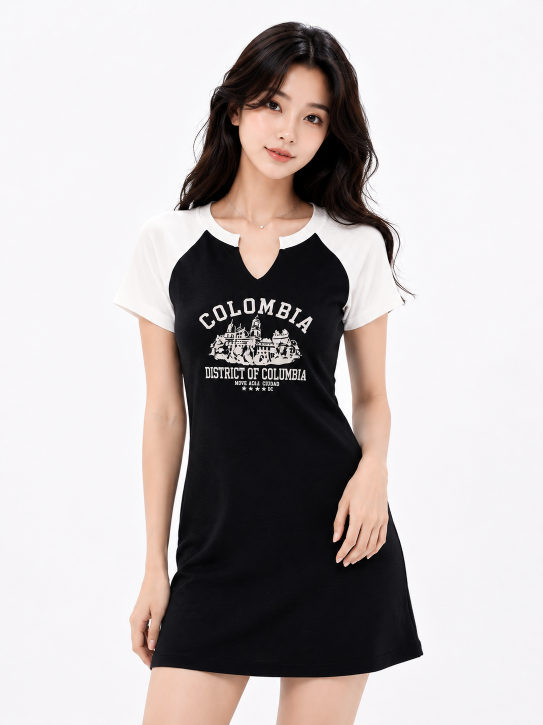 A woman modeling a black and white raglan-style mini dress with a white graphic print on the front reading 'COLOMBIA' and 'District of Columbia'.