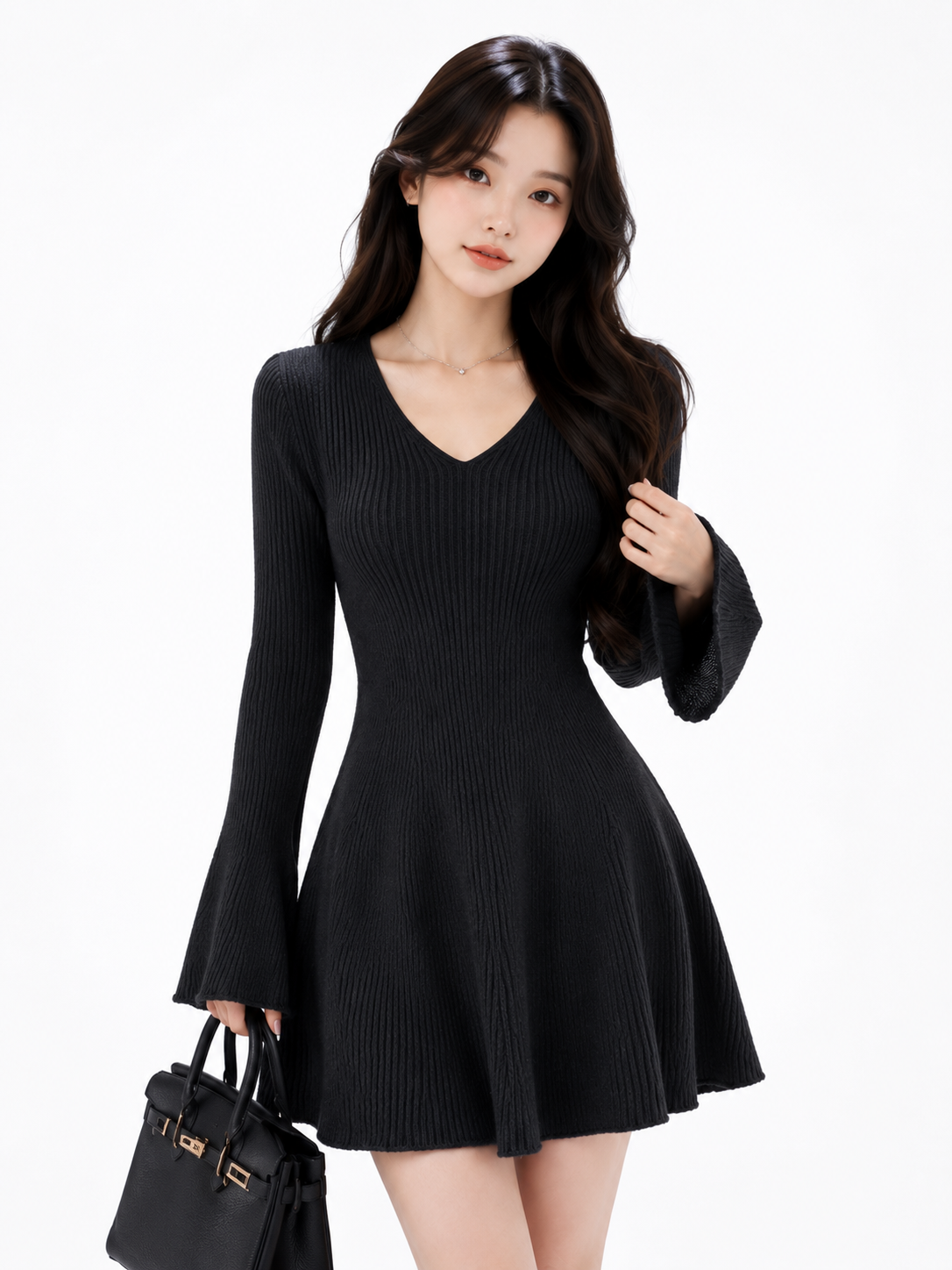 A woman modeling a black ribbed long-sleeve V-neck mini dress with flared bell sleeves and a flared skirt, holding a black handbag against a plain white background.