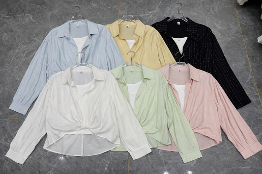 Set of pastel-colored shirts on hangers against a gray background