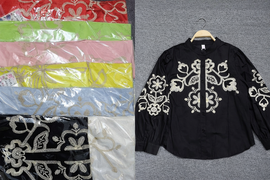 Black embroidered shirt on a gray surface with colorful fabric swatches below.