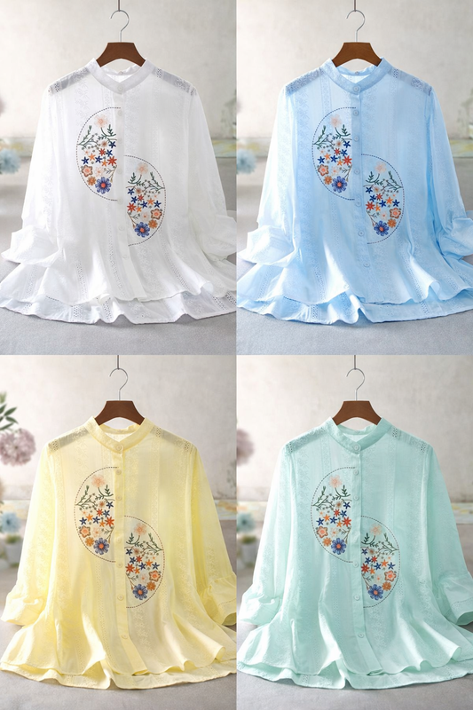 Four shirts in different colors with floral designs on a hanger against a neutral background.