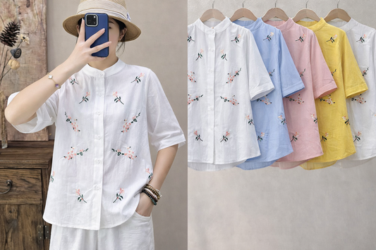 White embroidered shirt worn by a person and displayed on hangers with other colors.